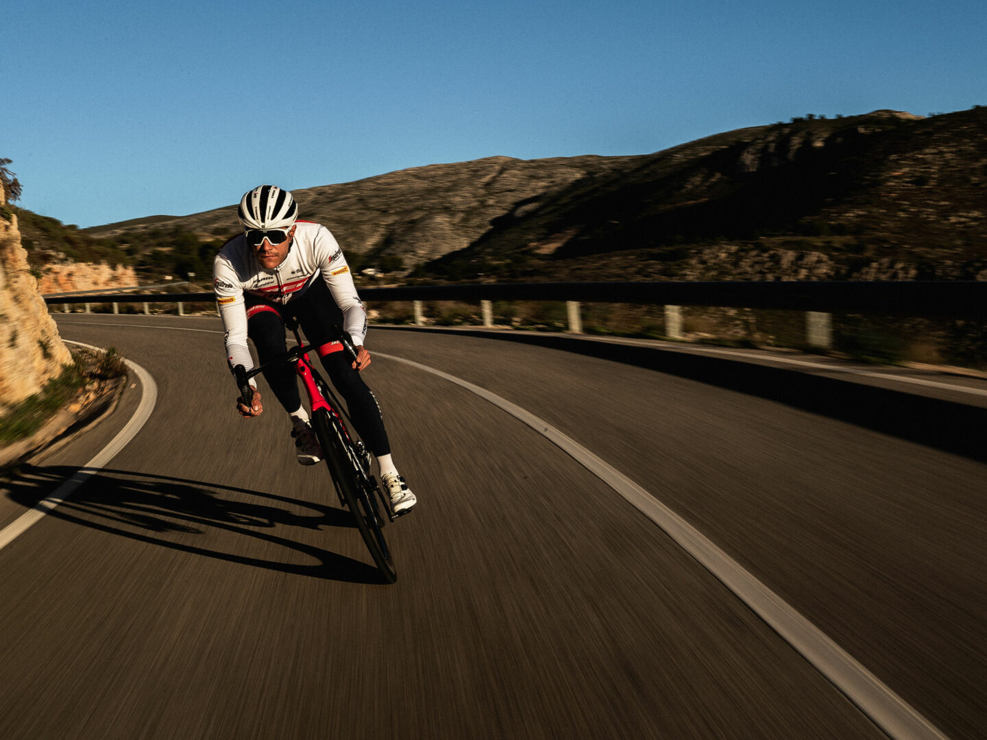 Trek-Segafredo-renner daalt in een canyon af in een aerodynamische lichaamshouding.